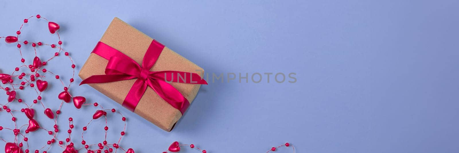 banner with flat lay of gift with red bow next to beads with hearts on very peri color background. holiday concept, congratulations, valentine's day, engagement, wedding, anniversary. top view. by Leoschka