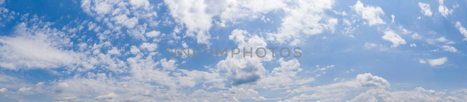 Panoramic view of blue sky with clouds and sunlight by EdVal