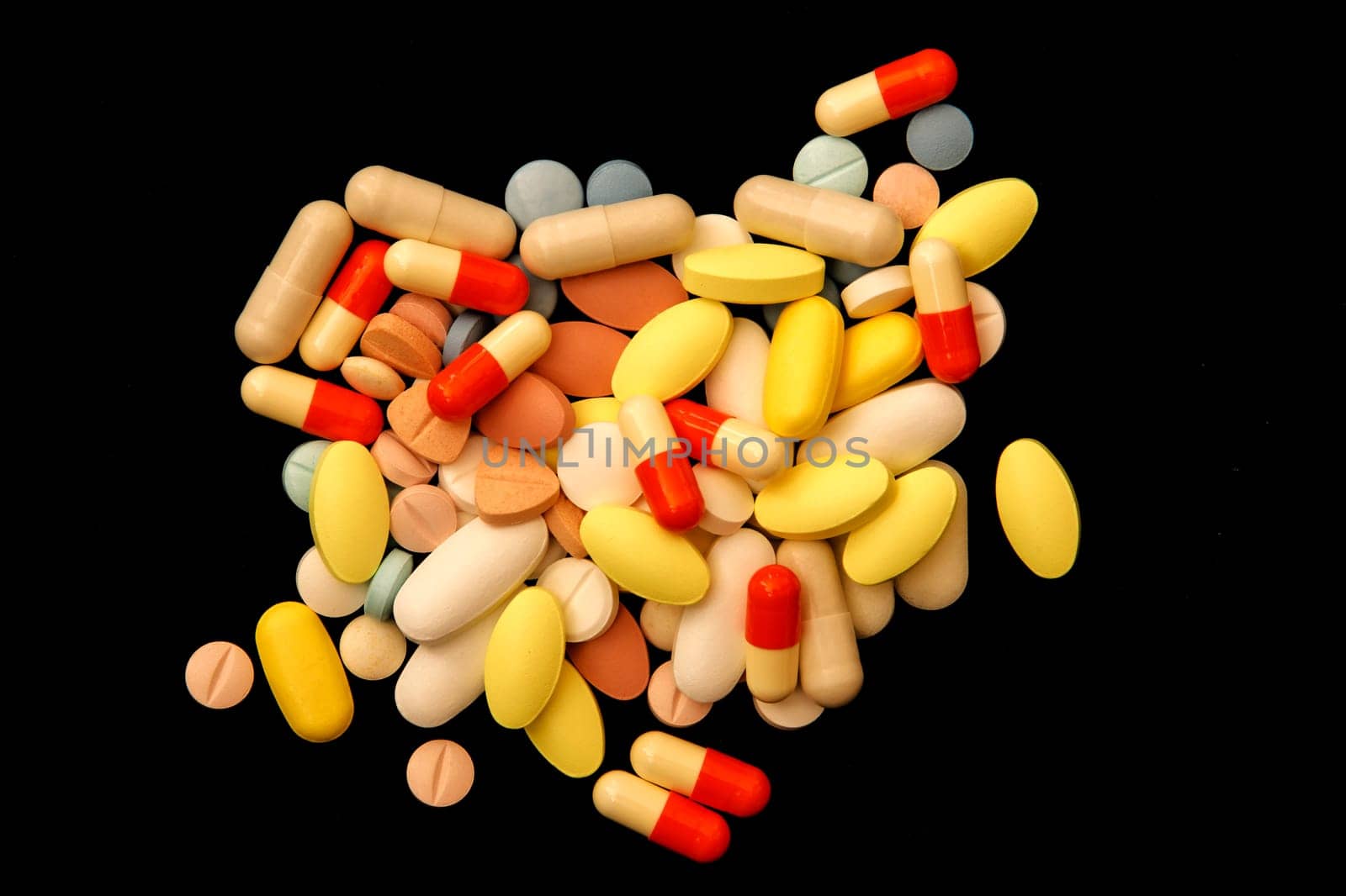 Many different colorful medications and pills. A pile of various multicolored drugs.