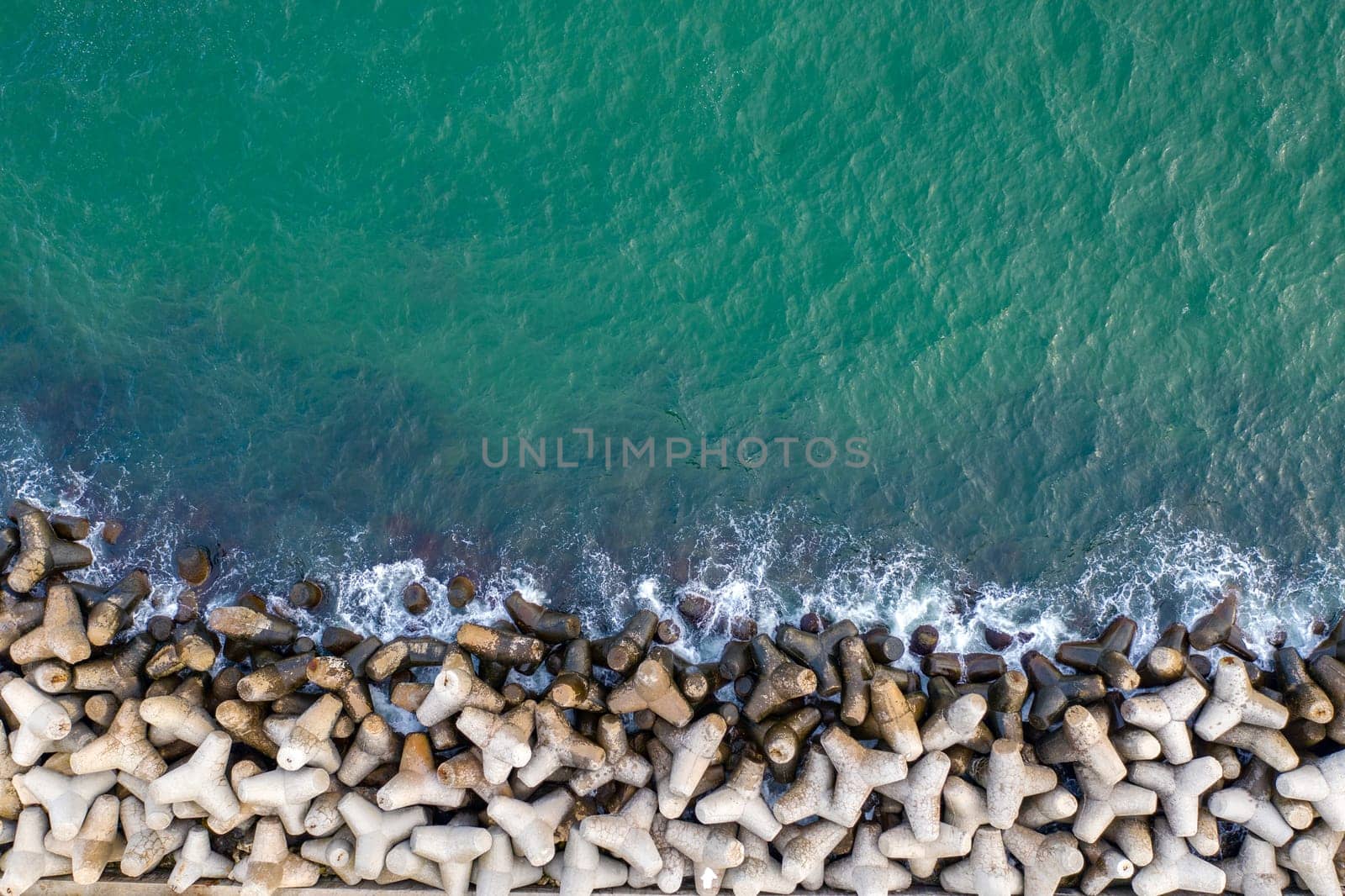Aerial top view from drone to the seacoast with breakwater