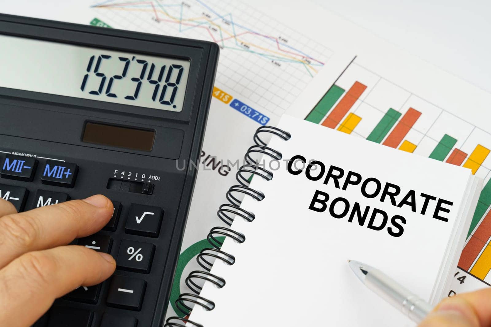 On the table there is a calculator, reports with graphs and a notepad with the inscription - Corporate Bonds by Sd28DimoN_1976