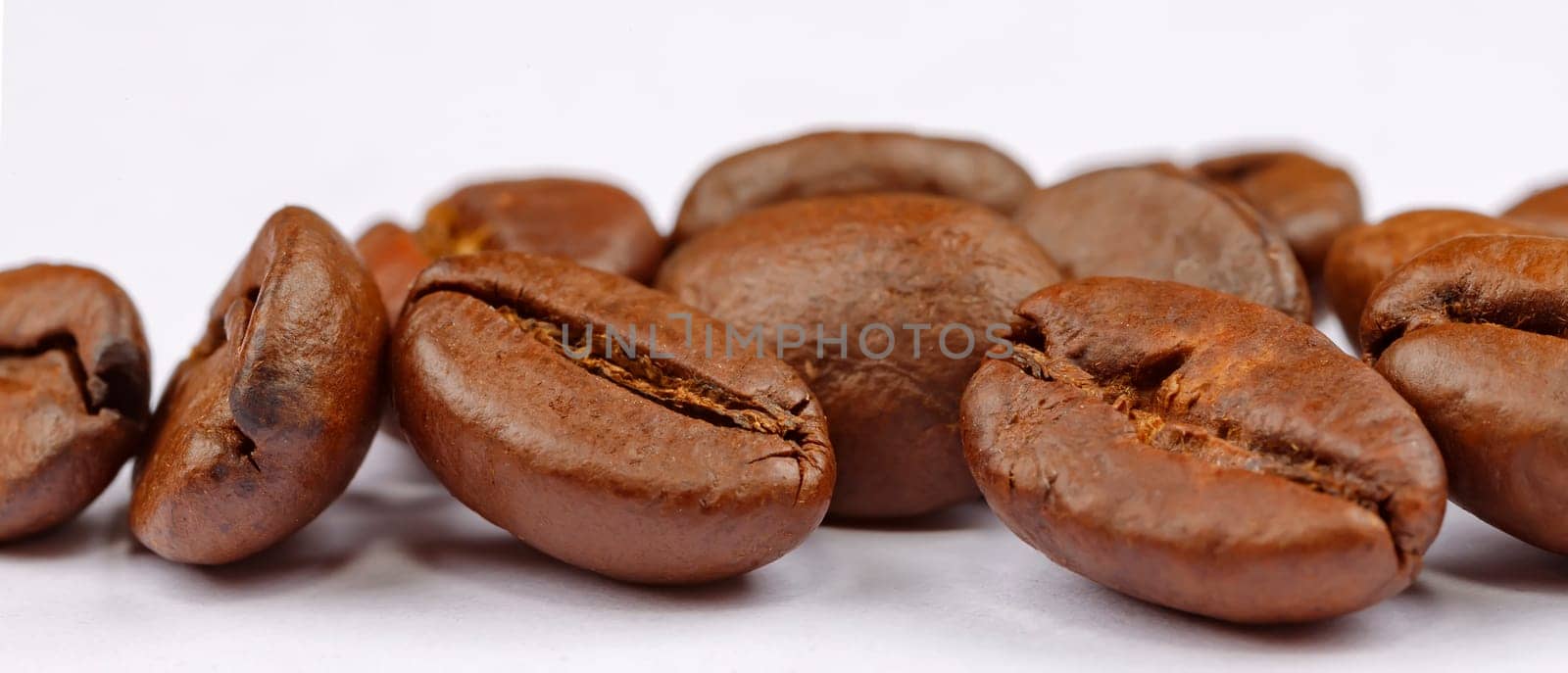 Panoramic view of coffee beans on white background