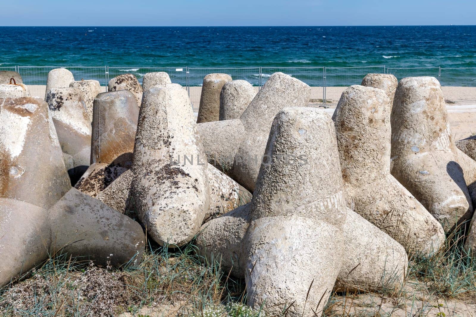 A breakwater made of concrete structures of tetrapods, installed on the coast. by EdVal