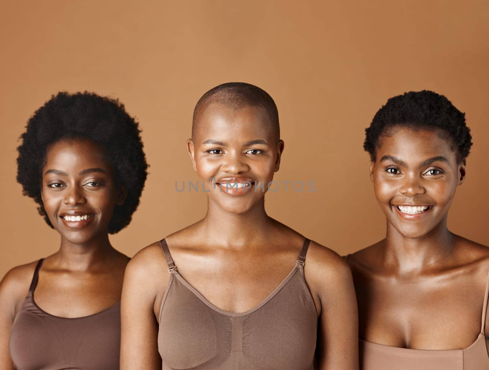 Face, skincare and natural with black woman friends in studio on a brown background for a wellness routine. Portrait, aesthetic and smile with a group of people looking happy at beauty treatment.