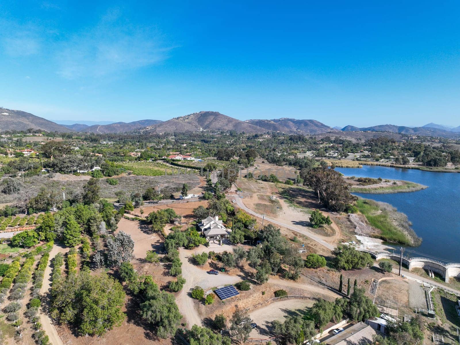 Aerial view over water reservoir and a large dam that holds water. Rancho Santa Fe in San Diego by Bonandbon