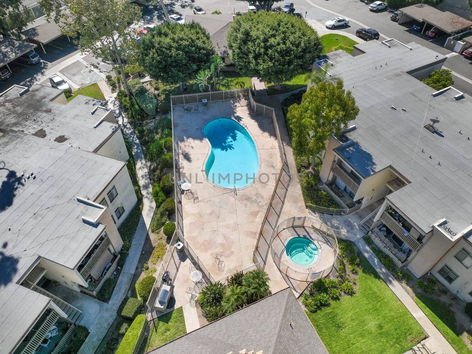 Gardens with pool and Jacuzzi in a the typical apartment complex building in San Diego, California by Bonandbon