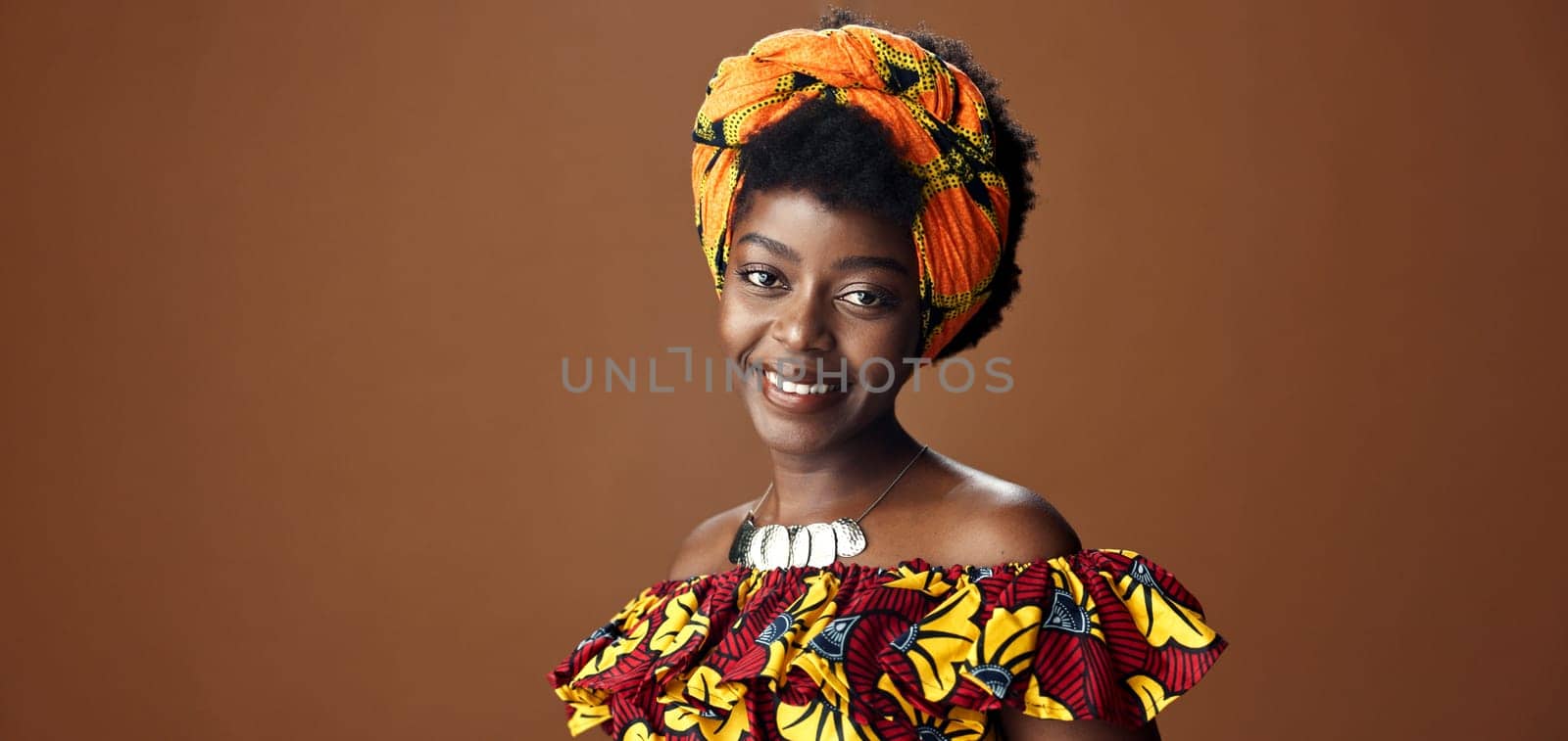 Wrap, fashion or face of happy black woman in studio on a brown background for trendy style. Smile, African or model with confidence, pride or afro posing in culture, clothes or traditional outfit by YuriArcurs