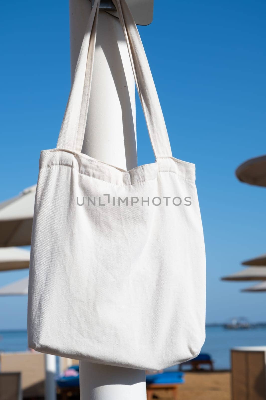 Mockup shopper handbag hanging on the beach. shopping eco reusable bag.