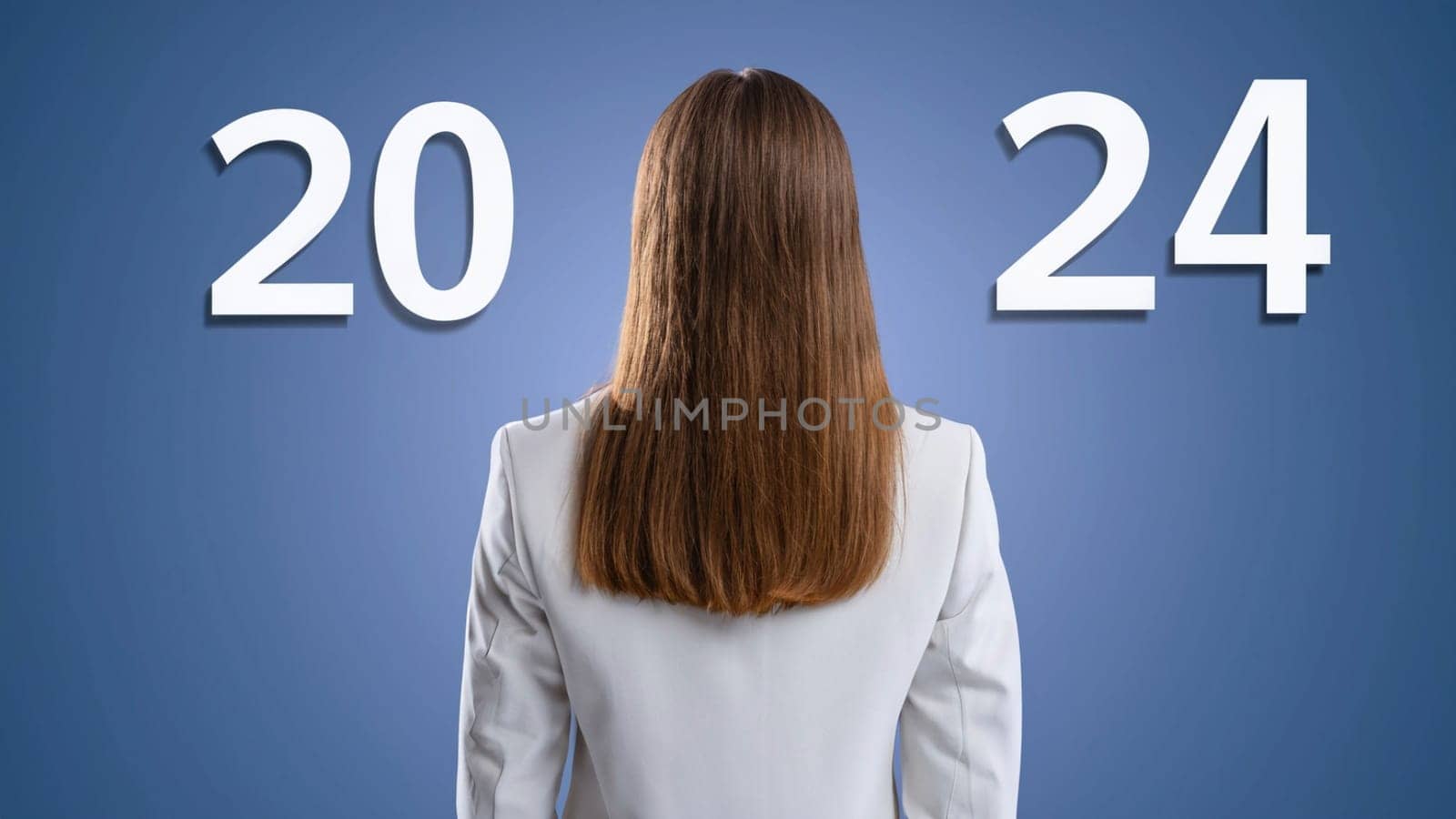 business woman with the new year 2024 . Businesswoman look at 2024 white color letter over blue background, Business happy new year 2024 cover concept. High quality image