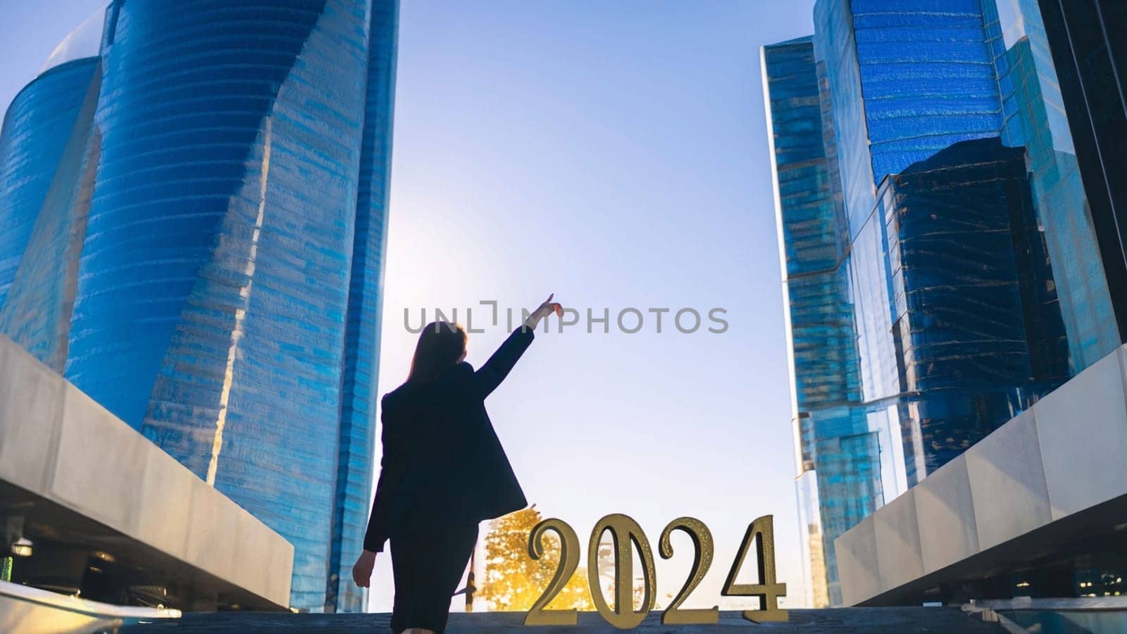 business woman with the new year 2024 for her eyes. Businesswoman point 2024 gold color letter and futuristic city background, Business happy new year 2024 cover concept. High quality image