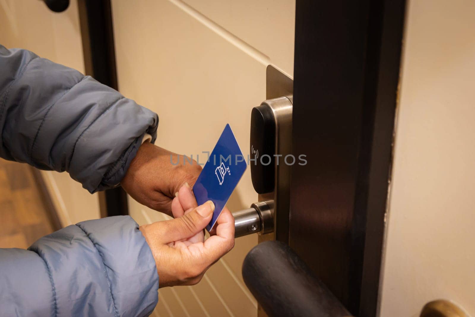 Woman hand using electronic smart key card to unlock door in hotel or house. Digital lock, door access control, contactless concept. Closeup, copy space.