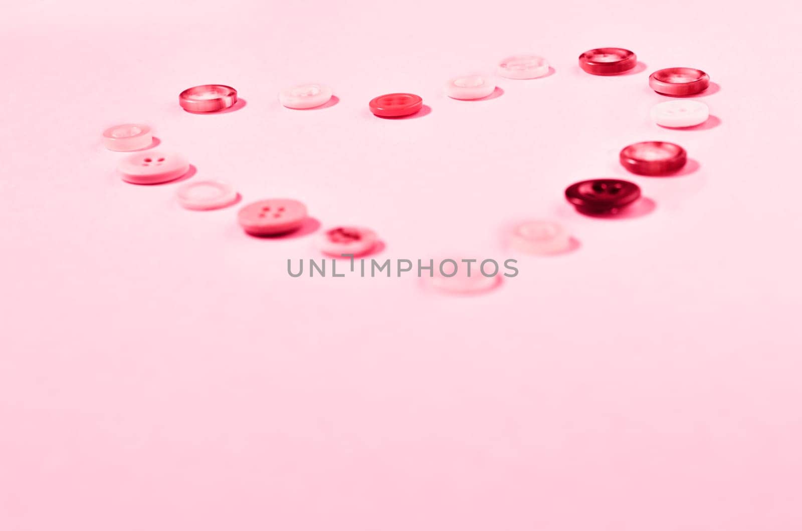 Red buttons forming heart shape on colored background , passion and love ,Valentine's day