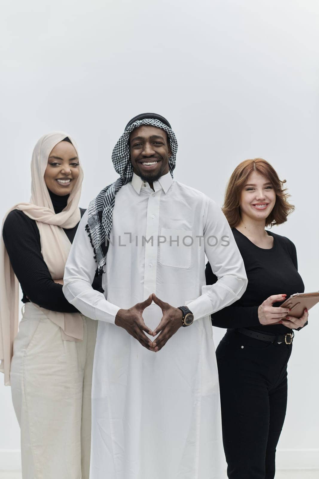 Arabic businessman stands confidently alongside two businesswomen, portraying a poised and diverse team that embodies ambition, innovation, and visionary leadership against a pristine white background by dotshock