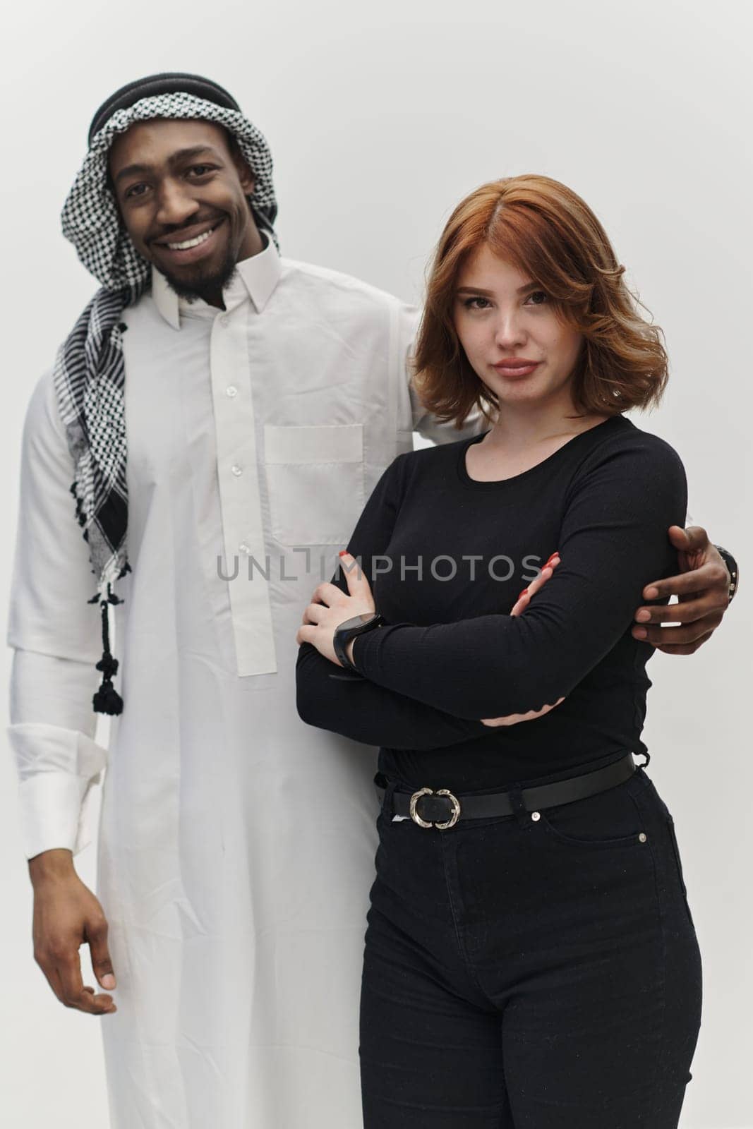 Muslim entrepreneur and a contemporary red-haired girl strike a pose together against a clean white background, embodying confidence, diversity, and a dynamic entrepreneurial spirit in their partnership.