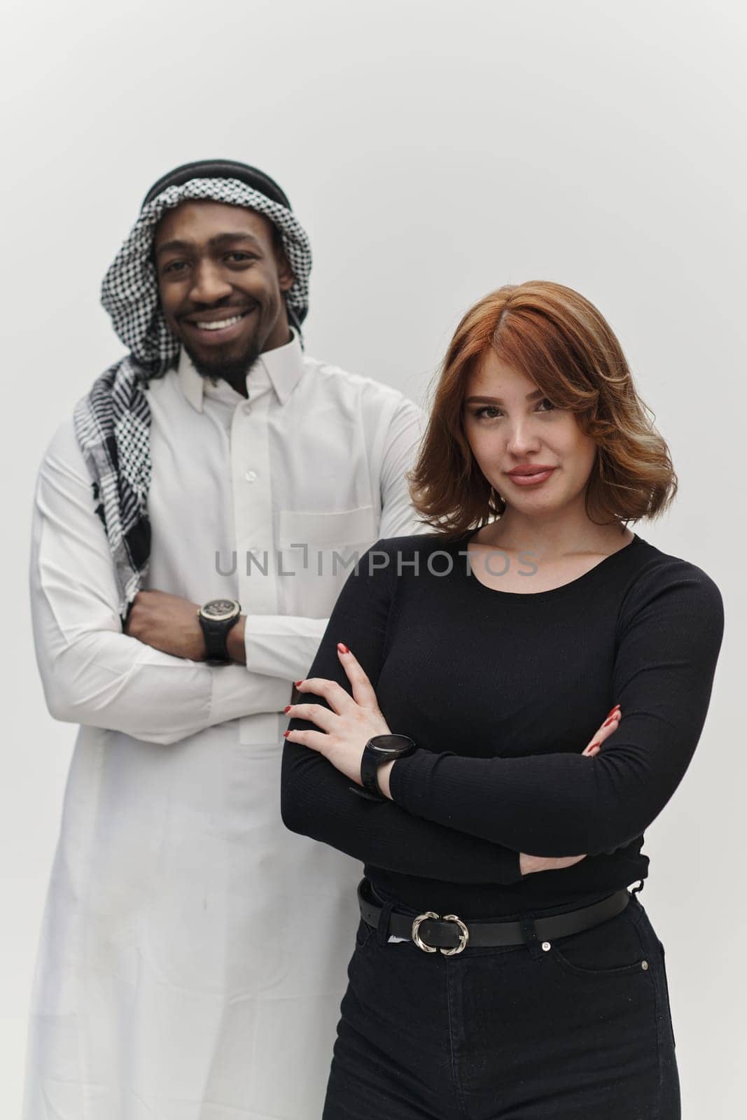 Muslim entrepreneur and a contemporary red-haired girl strike a pose together against a clean white background, embodying confidence, diversity, and a dynamic entrepreneurial spirit in their partnership by dotshock