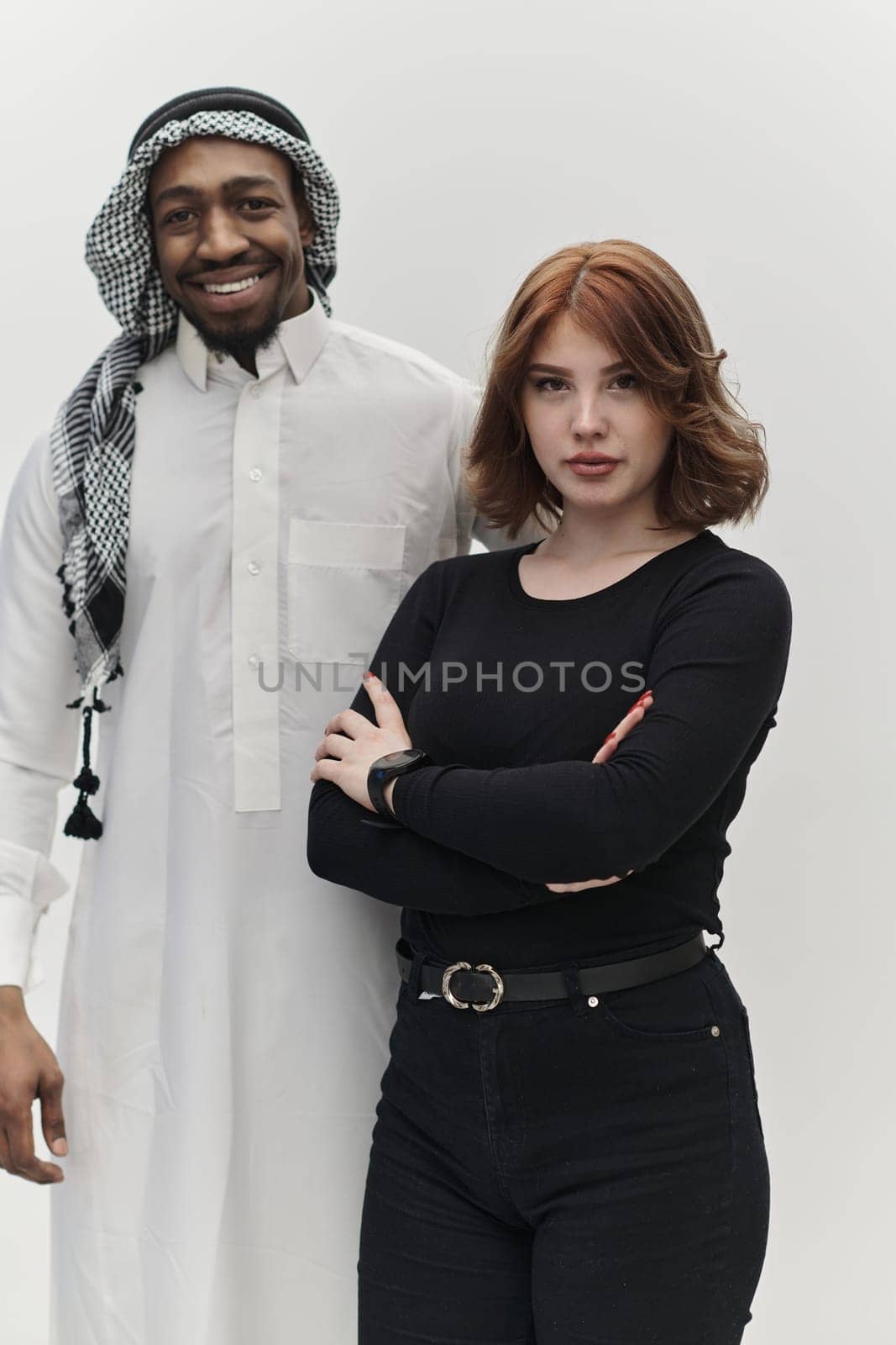 Muslim entrepreneur and a contemporary red-haired girl strike a pose together against a clean white background, embodying confidence, diversity, and a dynamic entrepreneurial spirit in their partnership.