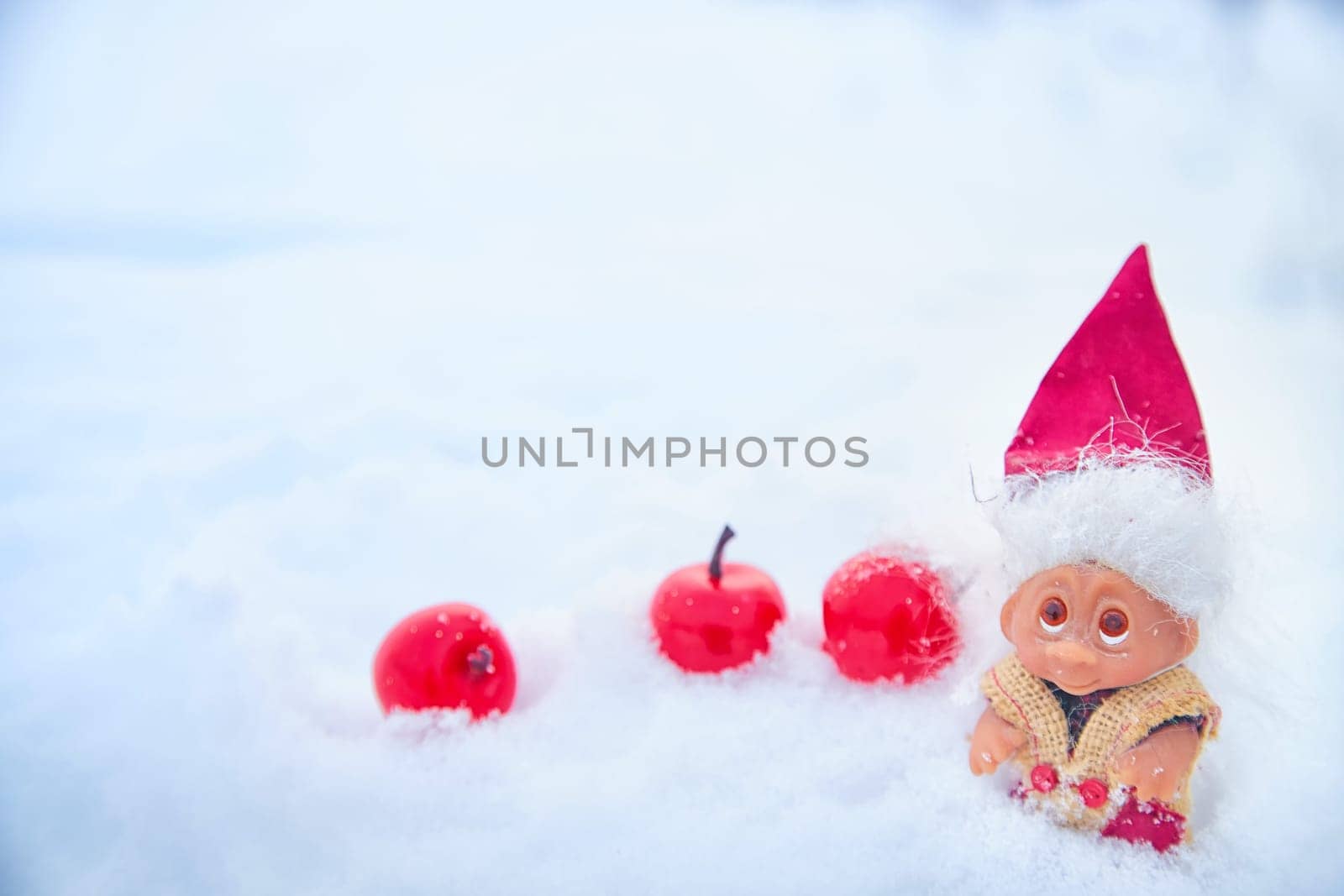 Cute little funny dwarf in the snow in the landscape in winter. Wizard on a snowy background. Christmas and New Year