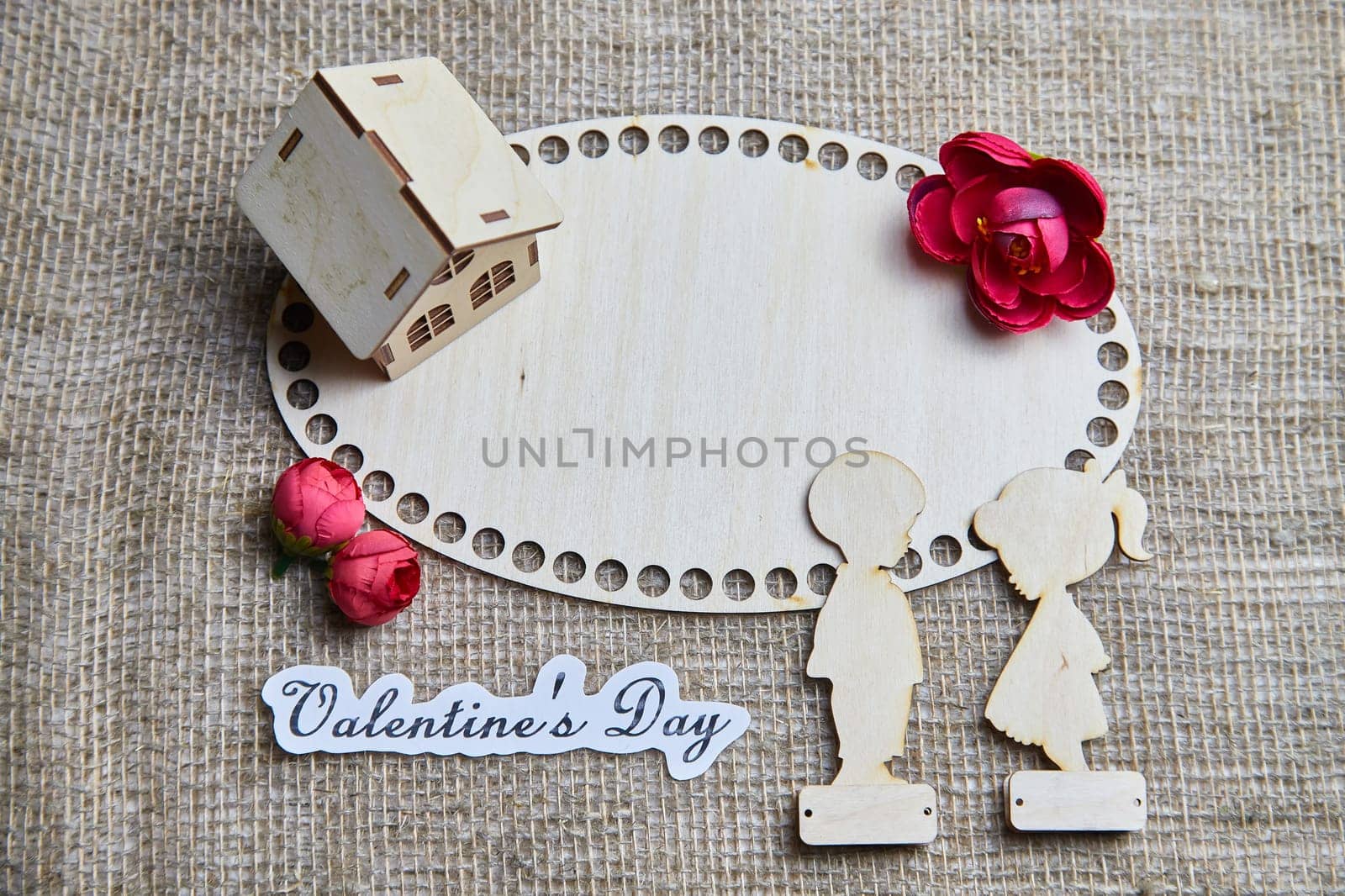 Wooden figurines of a couple, a house and the inscription Valentine's Day. The concept of a holiday of love and lovers. Background, texture, place for text and copy space