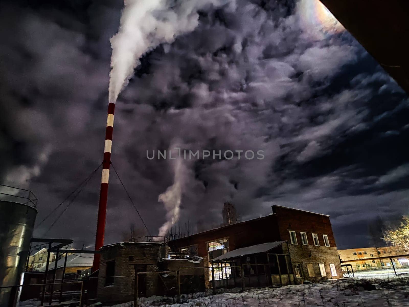 Winter night industrial landscape. Coal-fired power station with smoking chimneys against dramatic dark sky. Carbon dioxide CO2 emissions as primary driver of global climate change. Air pollution