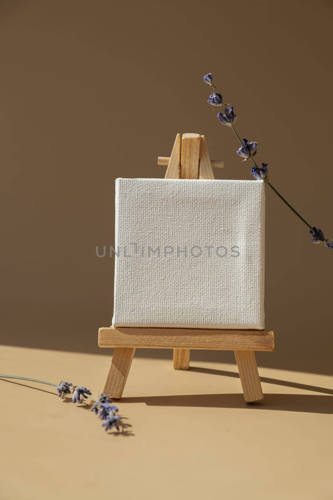 White paper note template mock up with dried lavender flower on neutral beige background. Copy space for your text. Advertisement sample. Earth tones