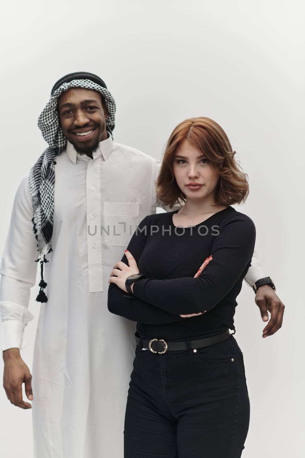 Muslim entrepreneur and a contemporary red-haired girl strike a pose together against a clean white background, embodying confidence, diversity, and a dynamic entrepreneurial spirit in their partnership.