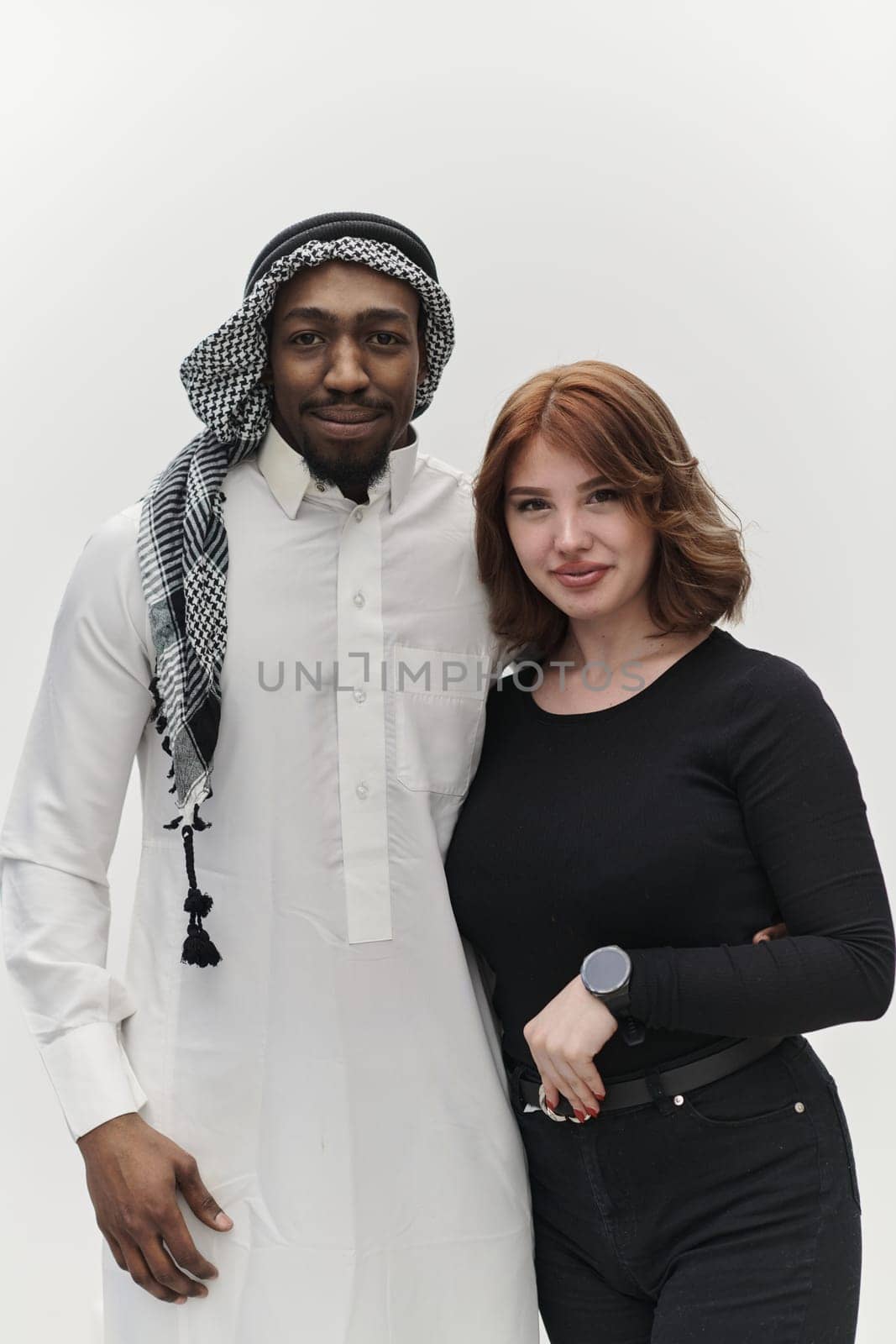 Muslim entrepreneur and a contemporary red-haired girl strike a pose together against a clean white background, embodying confidence, diversity, and a dynamic entrepreneurial spirit in their partnership.