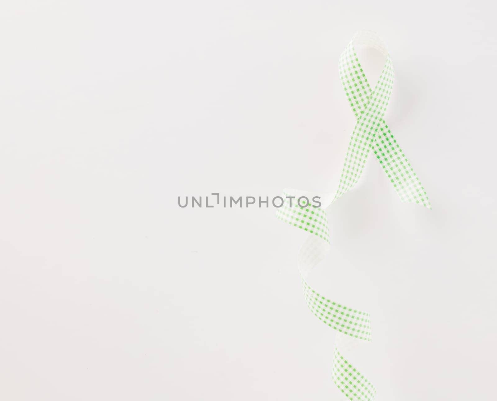 Green awareness ribbon of Gallbladder and Bile Duct Cancer month isolated on white background with copy space, concept of medical and health care support