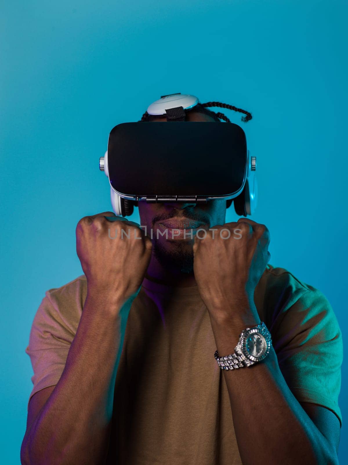 In an avant-garde scene, an African American man engages in cutting-edge virtual reality gaming, utilizing VR glasses to immerse himself in futuristic boxing games, set against a vivid blue background, showcasing the seamless fusion of technology, innovation, and interactive entertainment by dotshock
