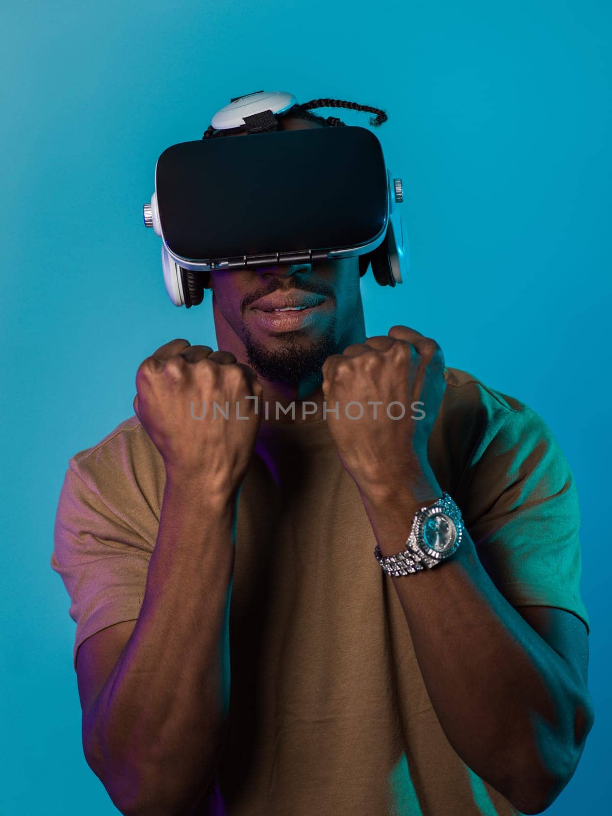 In an avant-garde scene, an African American man engages in cutting-edge virtual reality gaming, utilizing VR glasses to immerse himself in futuristic boxing games, set against a vivid blue background, showcasing the seamless fusion of technology, innovation, and interactive entertainment.