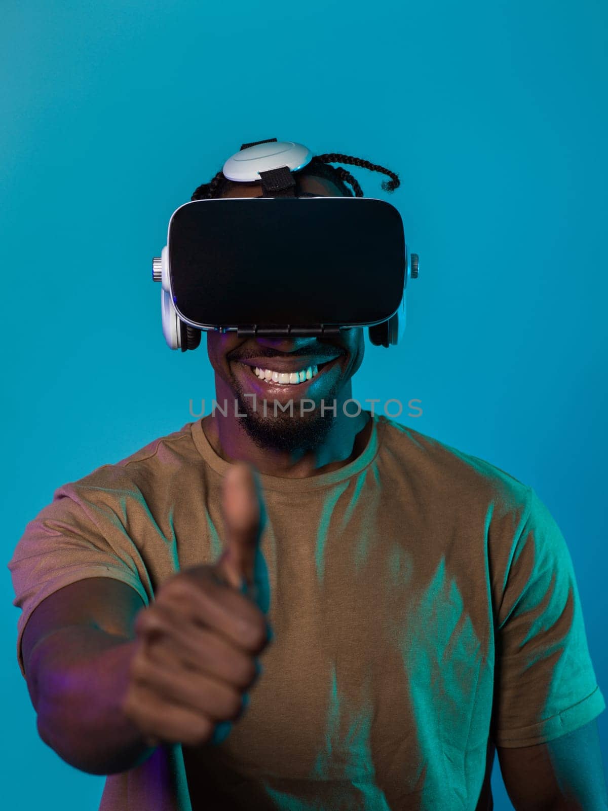 African American man wearing virtual reality glasses expresses satisfaction and impressed delight, gesturing with his hand pointed upward, while standing isolated against a vibrant yellow background, showcasing a positive and contented experience within the immersive virtual realm.