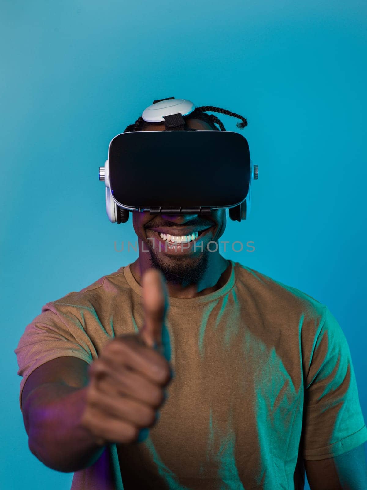 African American man wearing virtual reality glasses expresses satisfaction and impressed delight, gesturing with his hand pointed upward, while standing isolated against a vibrant yellow background, showcasing a positive and contented experience within the immersive virtual realm by dotshock