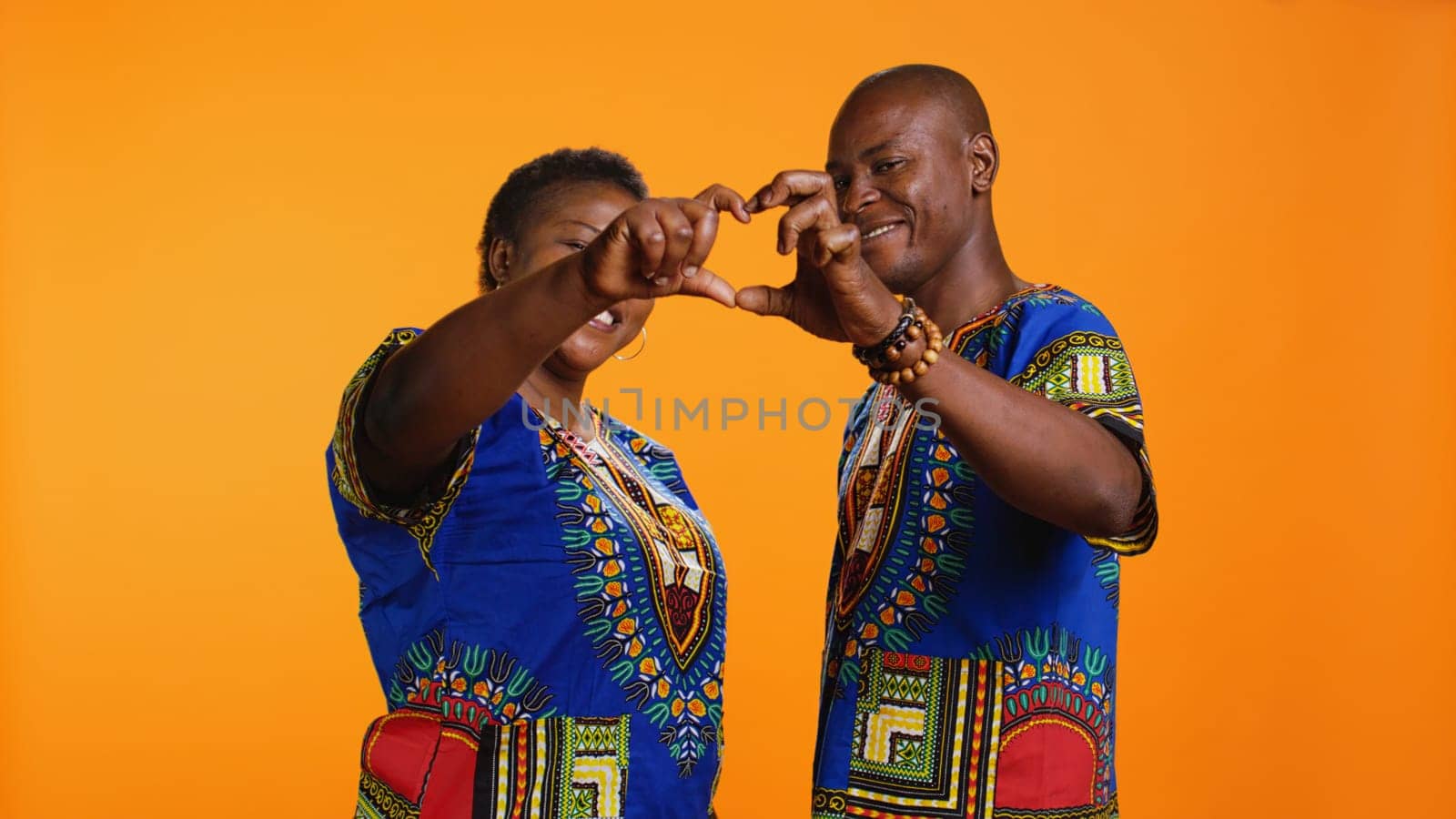 African american couple doing heart shaped sign by DCStudio