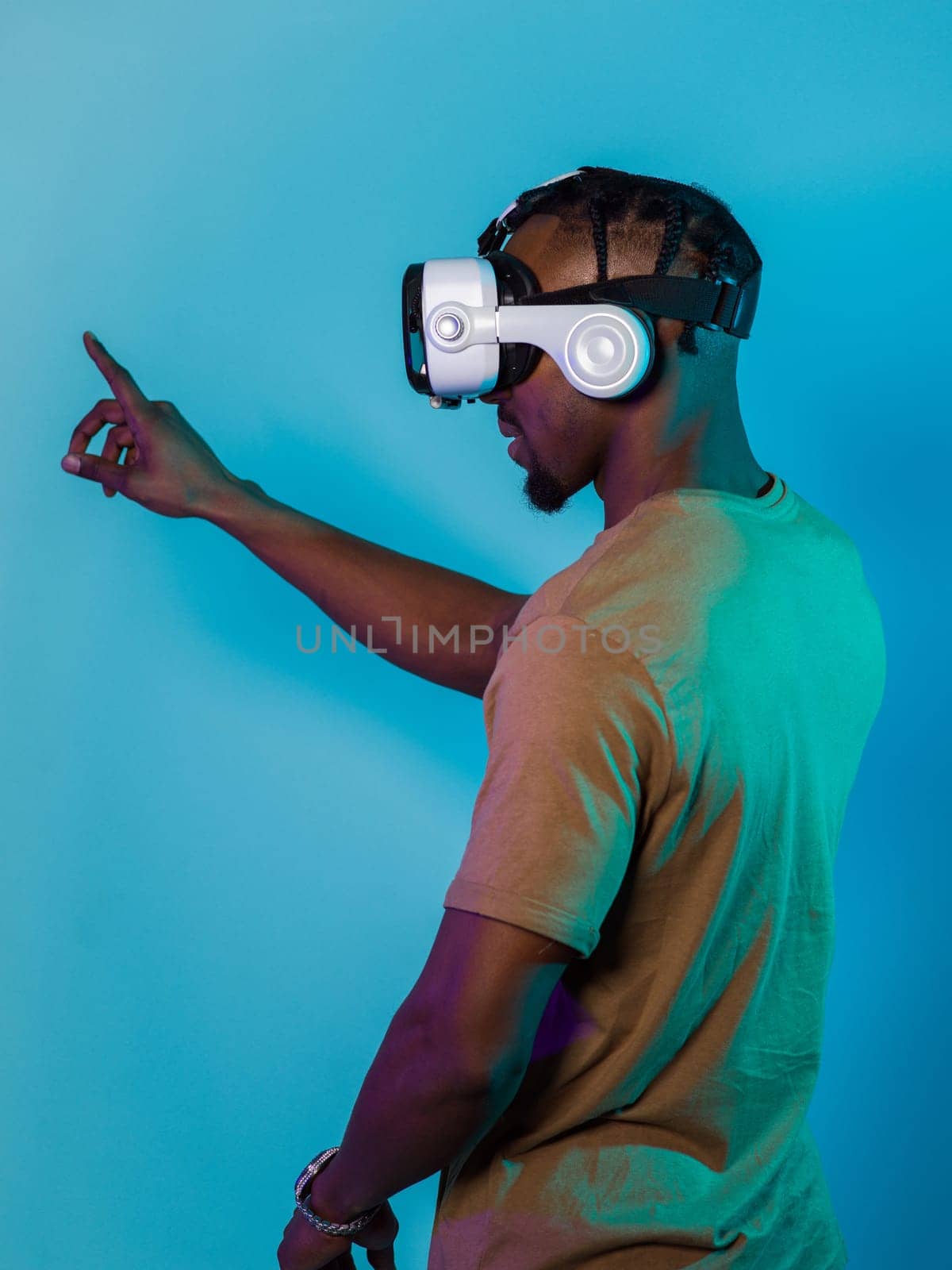 Immersed in a digital realm, an African American man navigates the virtual landscape with a VR goggles, using tactile gestures to interact with virtual objects, showcasing a harmonious blend of technology, innovation, and diverse empowerment by dotshock