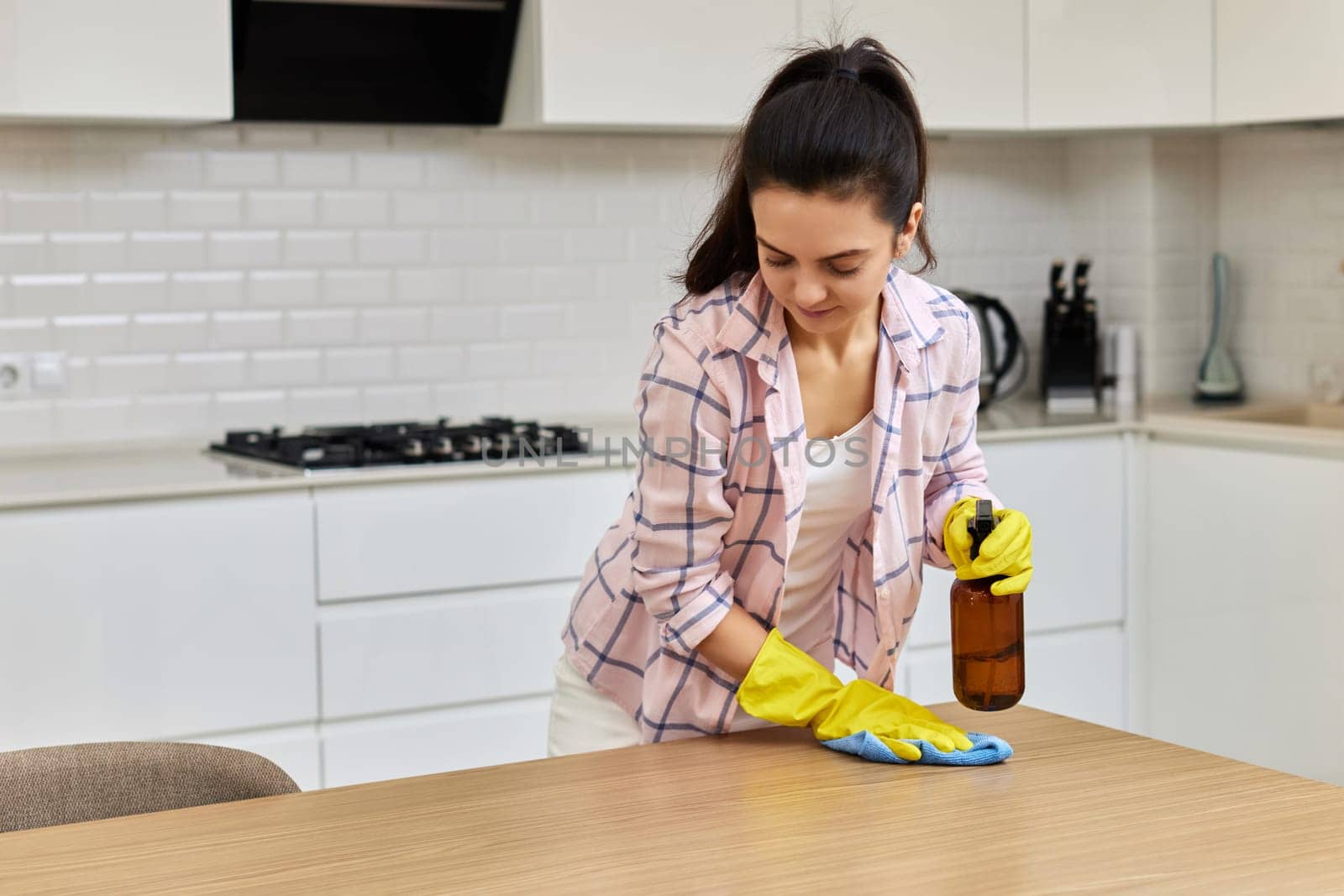 young woman in gloves cleaning and wiping wooden table with microfiber cloth. chores at home. Housekeeping