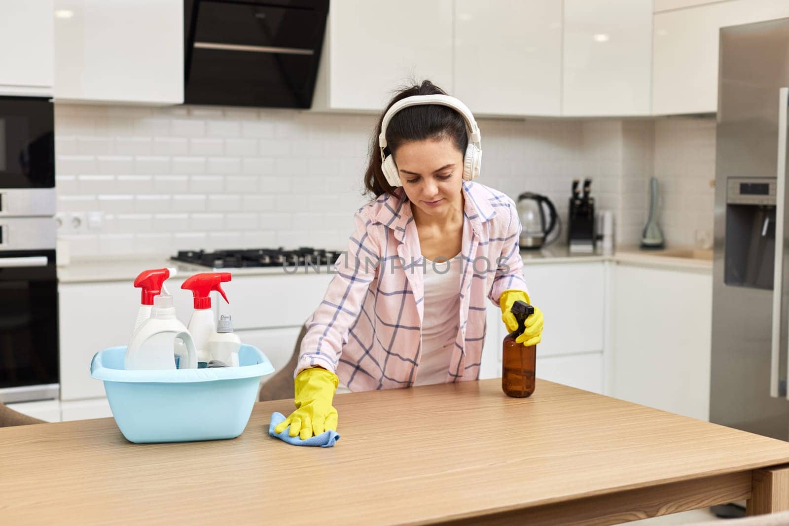 young woman in gloves cleaning and wiping wooden table with microfiber cloth. chores at home. Housekeeping