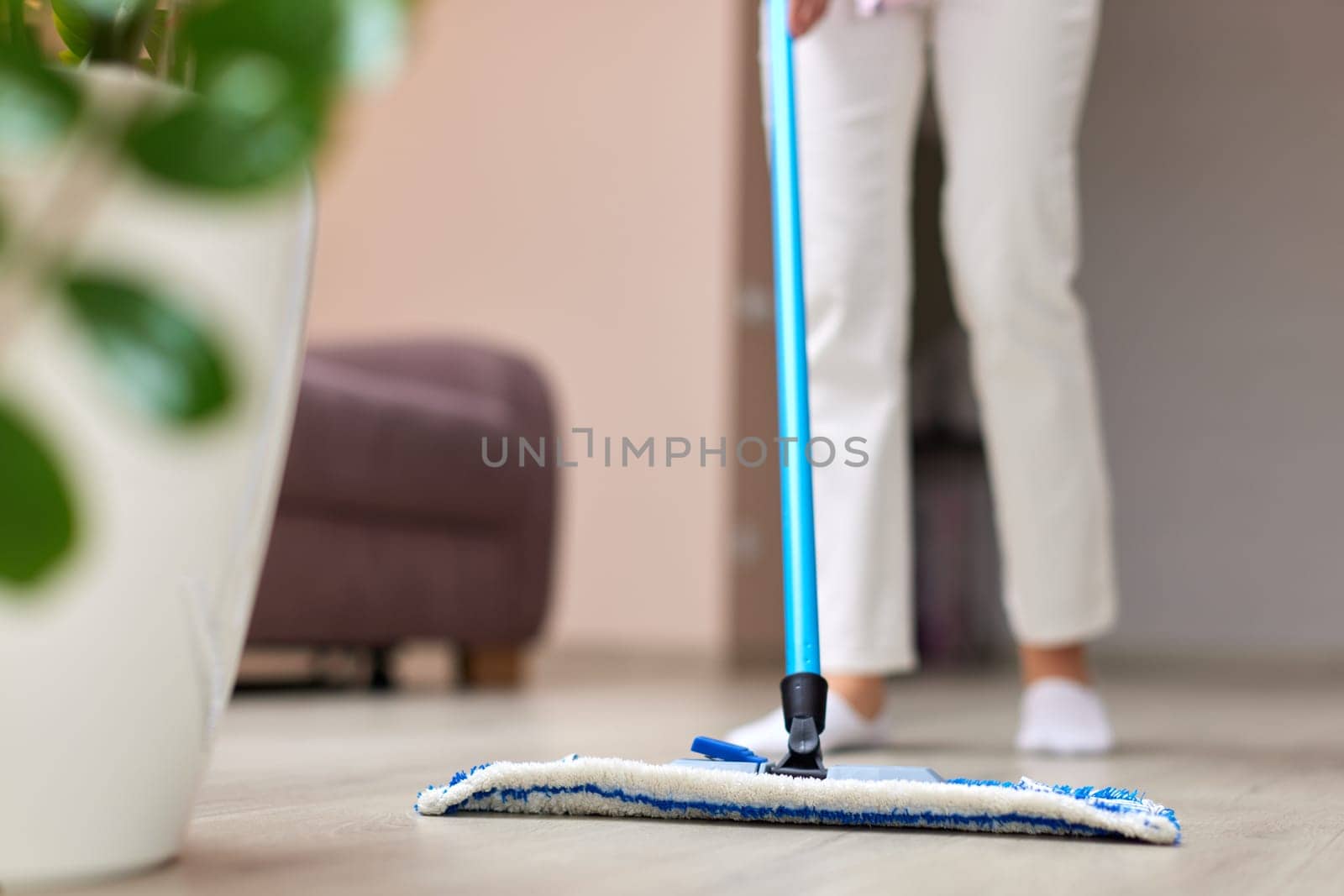 young woman cleaning and mopping floor at living room, daily housekeeping , close-up