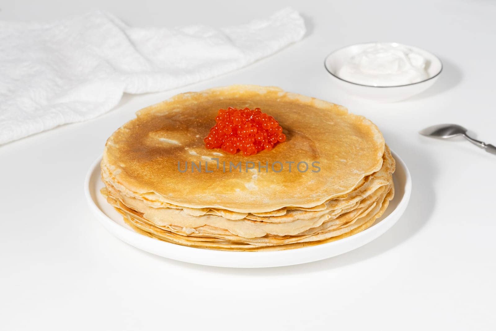 Pancakes with red caviar,Close-up of pancakes stacked on white background.