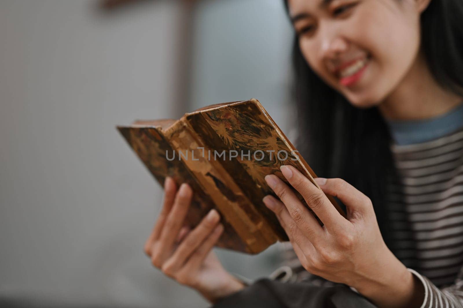 Charming young woman reading book at home. Hobbies, domestic life and lifestyle concept by prathanchorruangsak