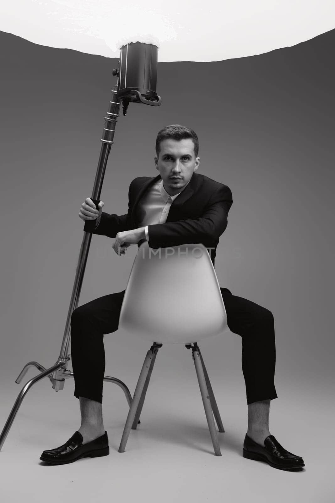 elegant model man in black suit in photostudio. black and white