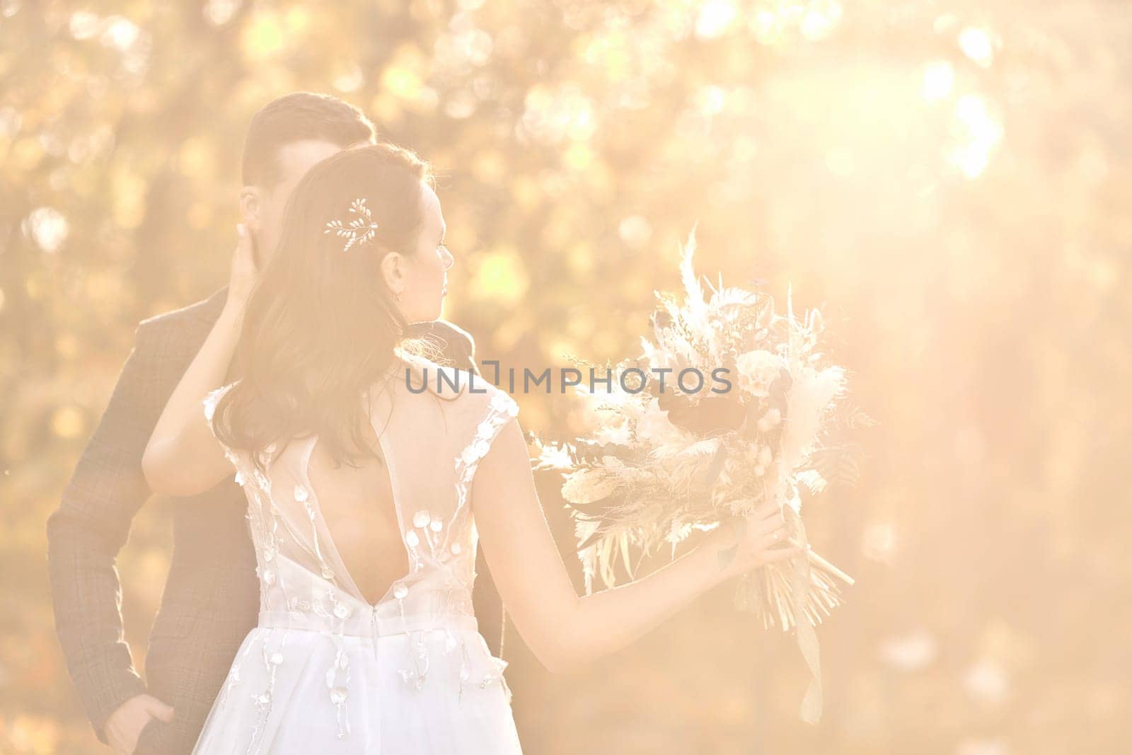 beautiful bride and groom standing outdoor on natural background in sunny day. copy space