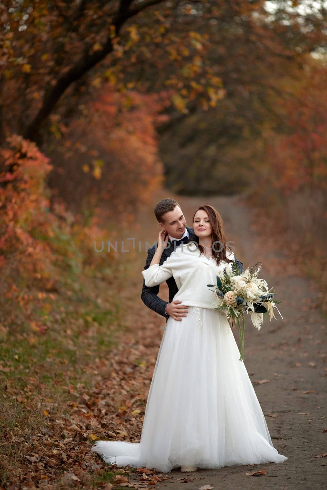 happy bride in white wedding dress and groom standing outdoor on natural background