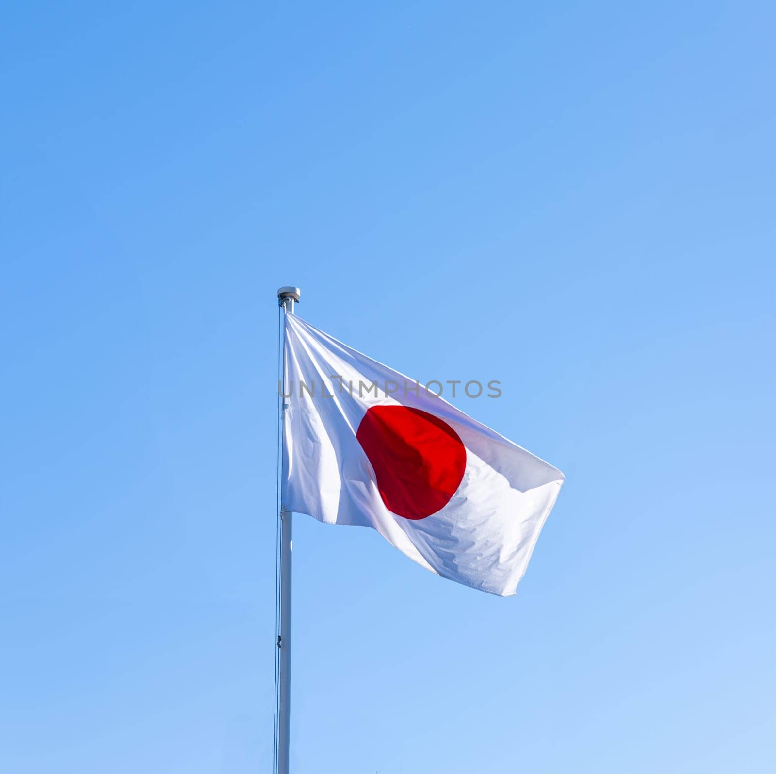 The Japanese flag with a blue sky on the background