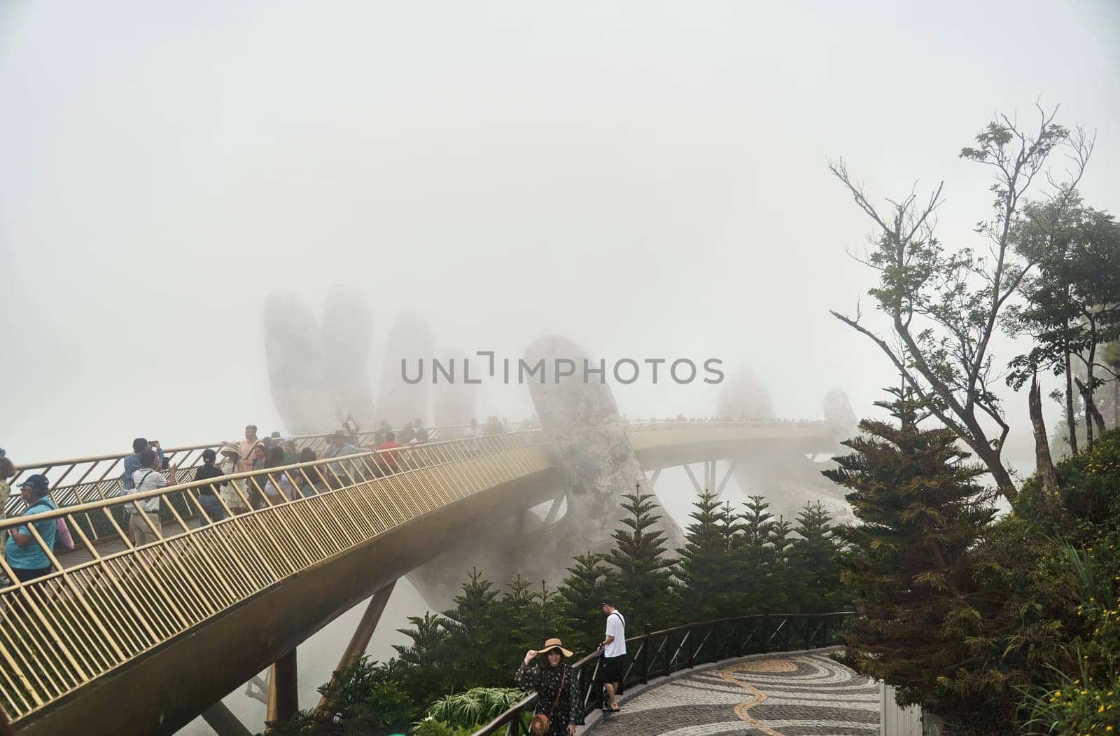 Danang, Vietnam - June 27, 2023: The Golden Bridge is lifted by two giant hands in the tourist resort on Ba Na Hill in Danang, Vietnam.