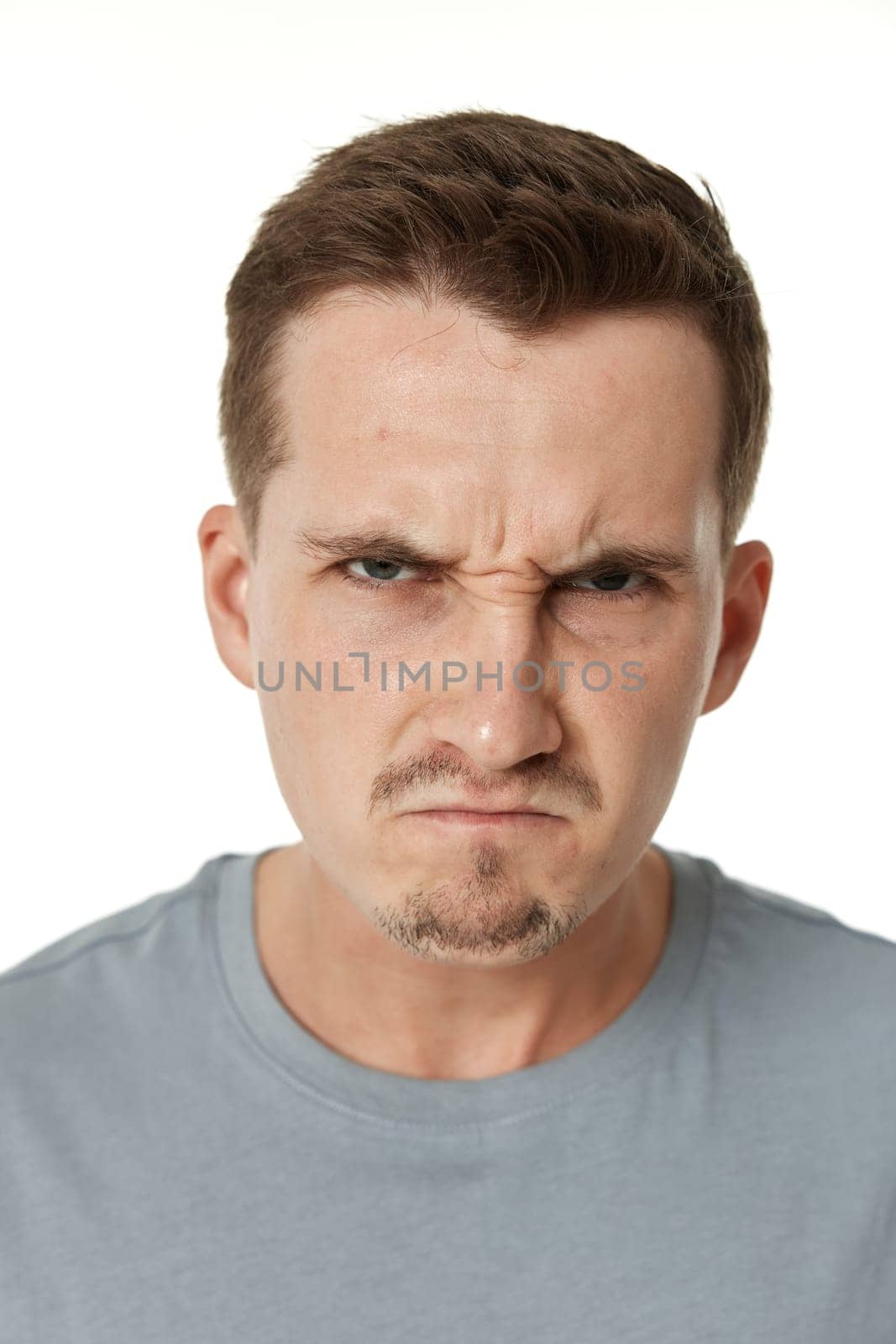 annoyed angry man standing on white studio background