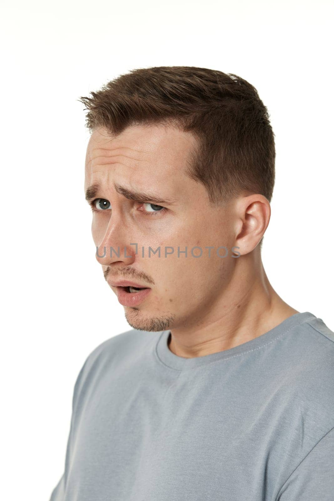 offended frustrated young man on white background. sadness