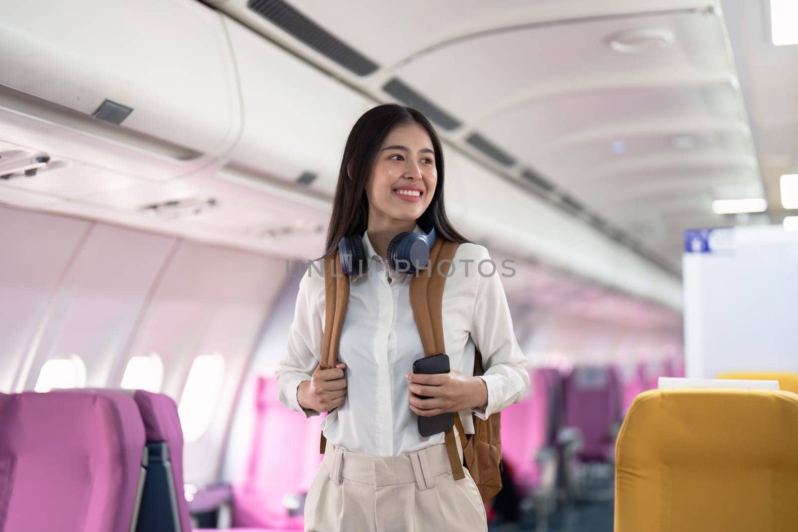 Alone Asian woman passenger traveling by plane. happy traveler on board. Solo travel concept by nateemee