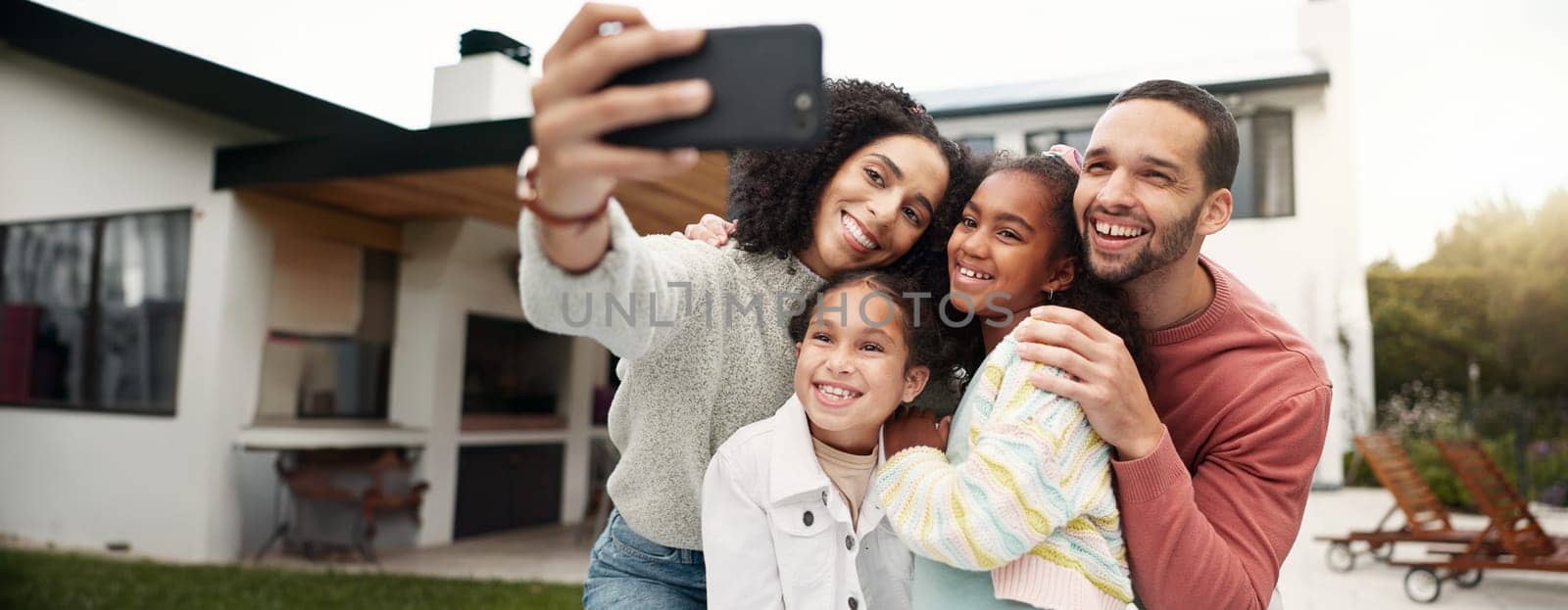 Children, family and selfie outdoor with a smile, love and care in home backyard. Young latino woman and man or parents hug happy girl kids for a profile picture or social media post on holiday.