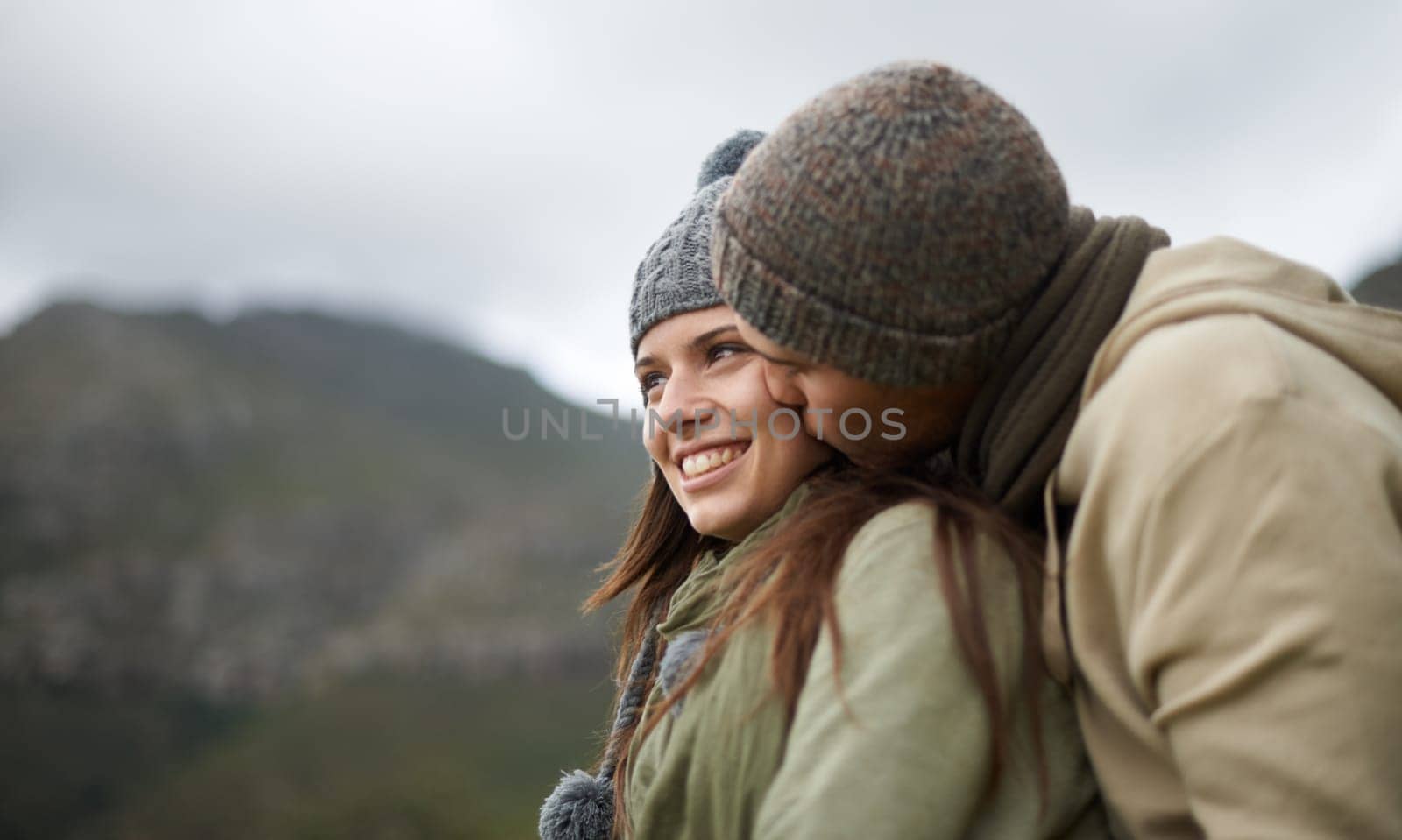 Couple, kiss and love on hike in nature together, bonding and romance in outdoors on mountain. Winter, people and security and connection in relationship or marriage, holiday and trekking adventure.