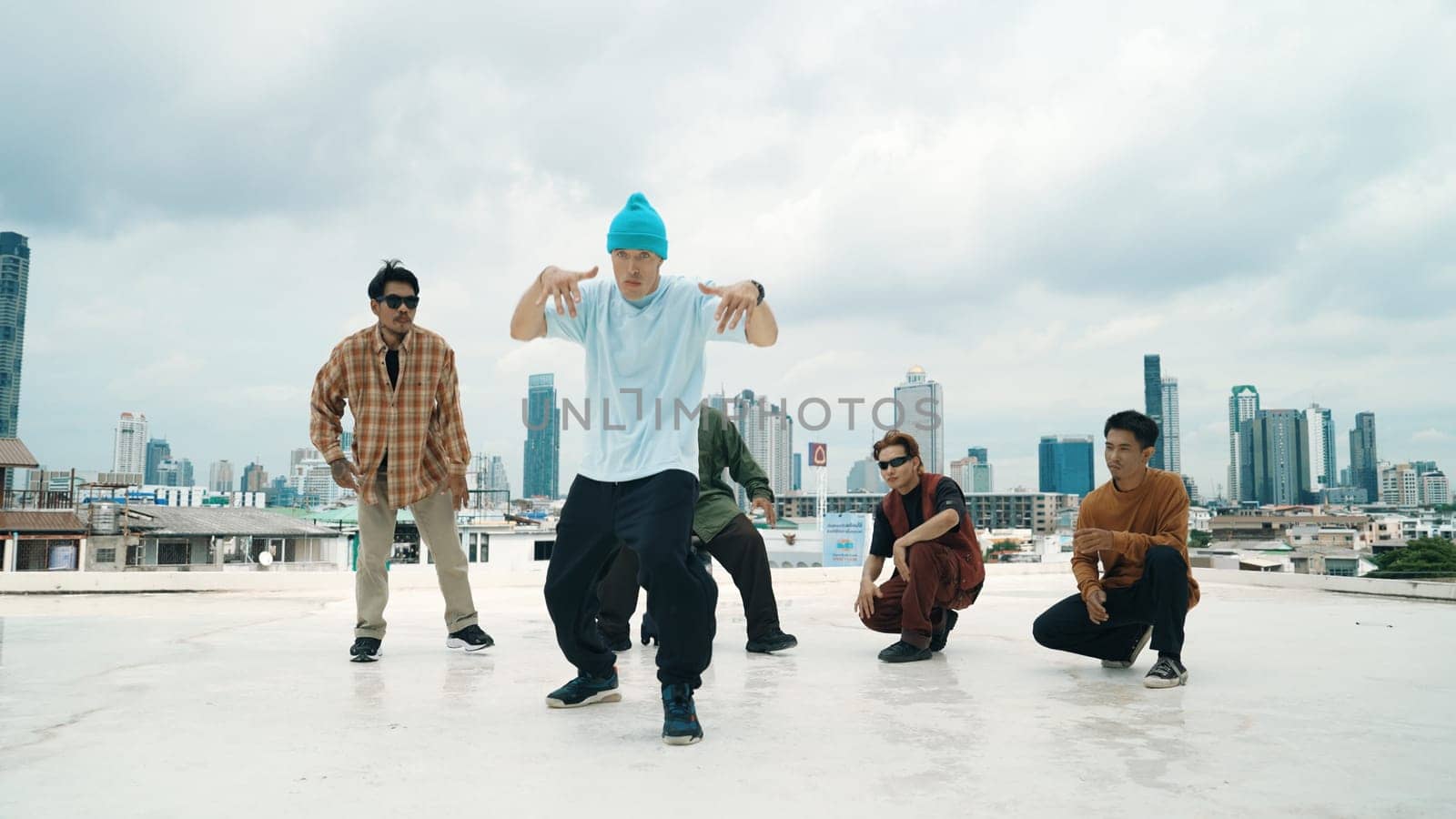 Professional break dance team practice B-boy dance while multicultural friends at rooftop. Young modern dancing group doing hip hop movement. Style,fashion,action. Outdoor sport 2024. Endeavor.