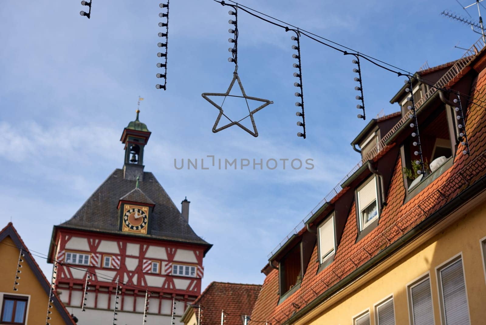 Festive Bietigheim-Bissingen: City Hall, New Year Decorations, Rooftops, Half-Timbered Houses. Discover the enchanting beauty of Bietigheim-Bissingen as the City Hall stands adorned with New Year decorations. The cityscape, with its charming rooftops and half-timbered houses, paints a festive and picturesque scene. Immerse yourself in the holiday spirit as the historic architecture comes alive with seasonal charm.